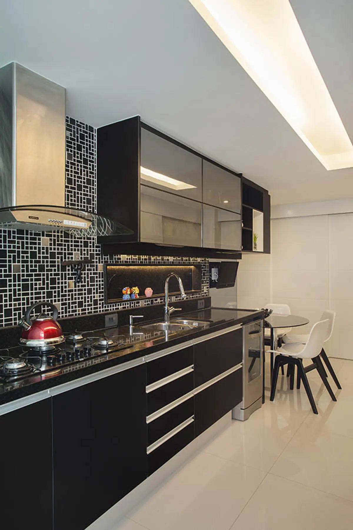 Cocina moderna negra con mesada de mármol y azulejos blancos — proyecto Apartamento Recreio, por Amanda Miranda