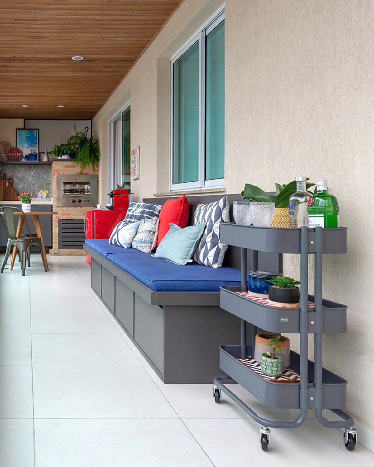 Balcón contemporáneo con banqueta, cojines coloridos y estantes con plantas — proyecto Apartamento Nóbrega, por Amanda Miranda