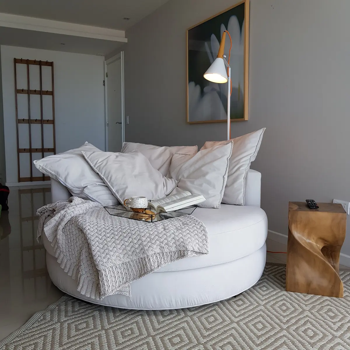 Living moderno con sillón circular blanco y lámpara de pie arqueada — proyecto Departamento MH, por Vicky Hurrell, en Mar del Plata