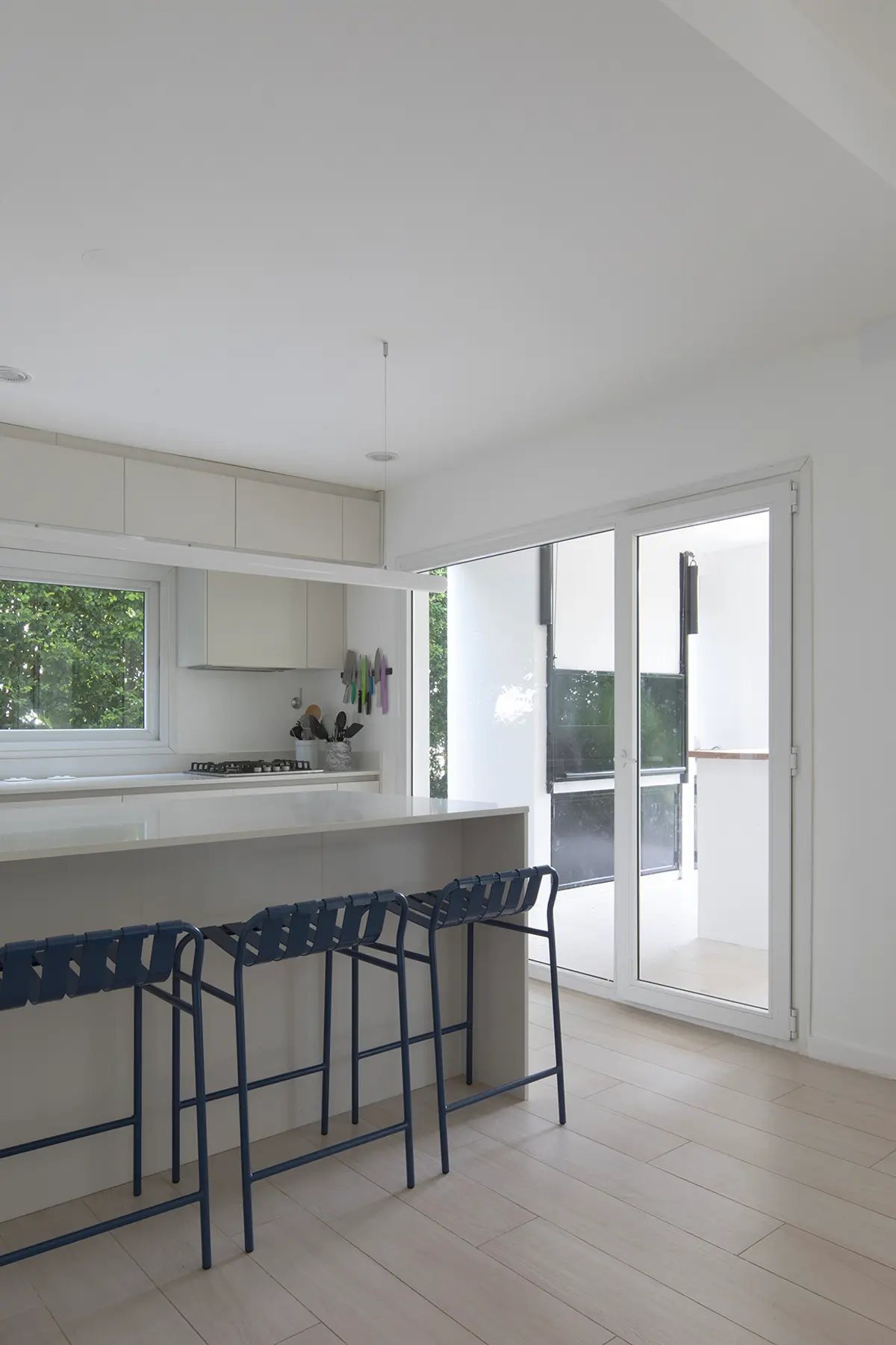 Cozinha moderna com ilha, balcão e janelas amplas — projeto Reforma Isla del Sol, por Estudio YME, em Rincón de Milberg