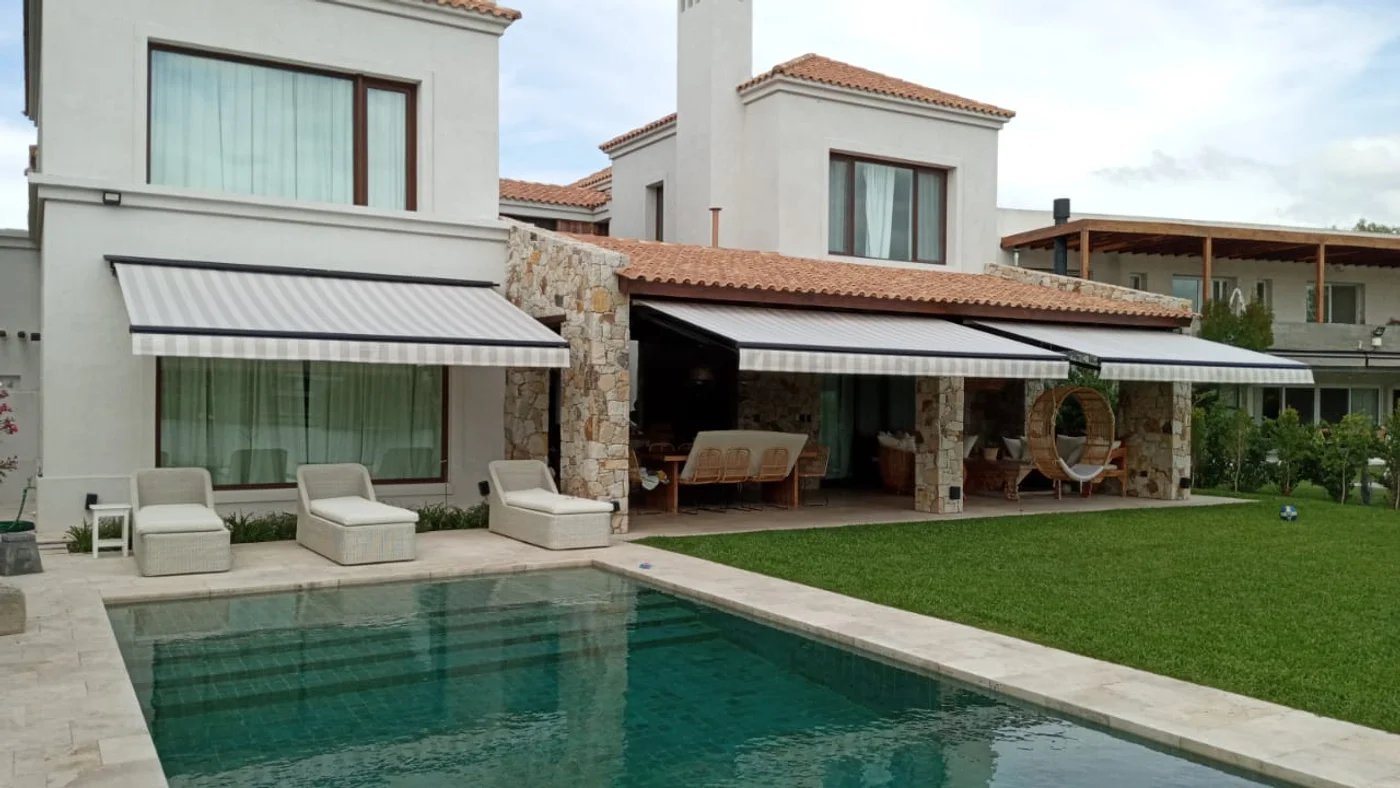 Terraza moderna con piscina y toldos retráctiles