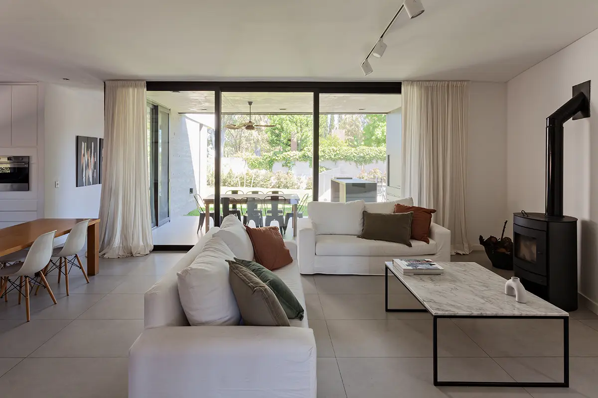 Sala de estar moderna minimalista com sofá branco e janelas do chão ao teto — projeto CASA RDV, por Rastro Estudio, em San Isidro