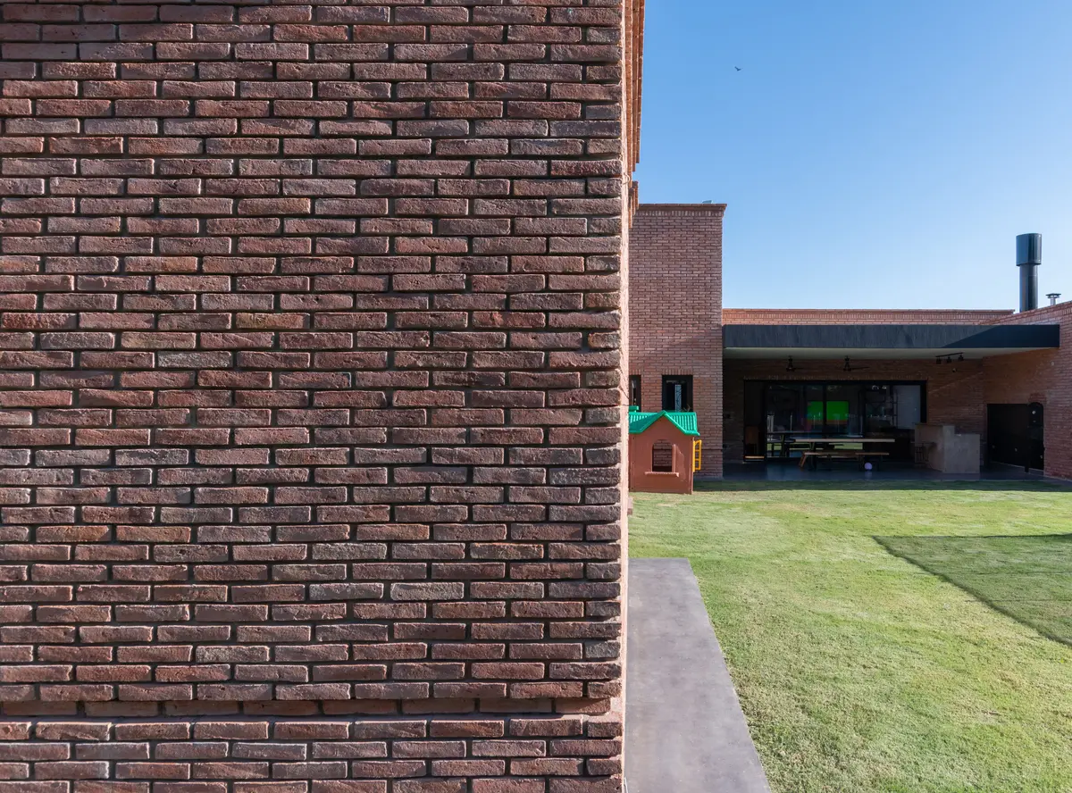 fachada moderna de ladrillos con jardín — proyecto VIVIENDA L.L, por Lorenabusquetsarquitectura, en Córdoba