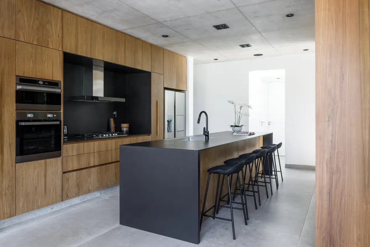 Cocina moderna minimalista con isla central y acabados en madera y hormigón — proyecto CASA AH, por GMARQ, en Garin