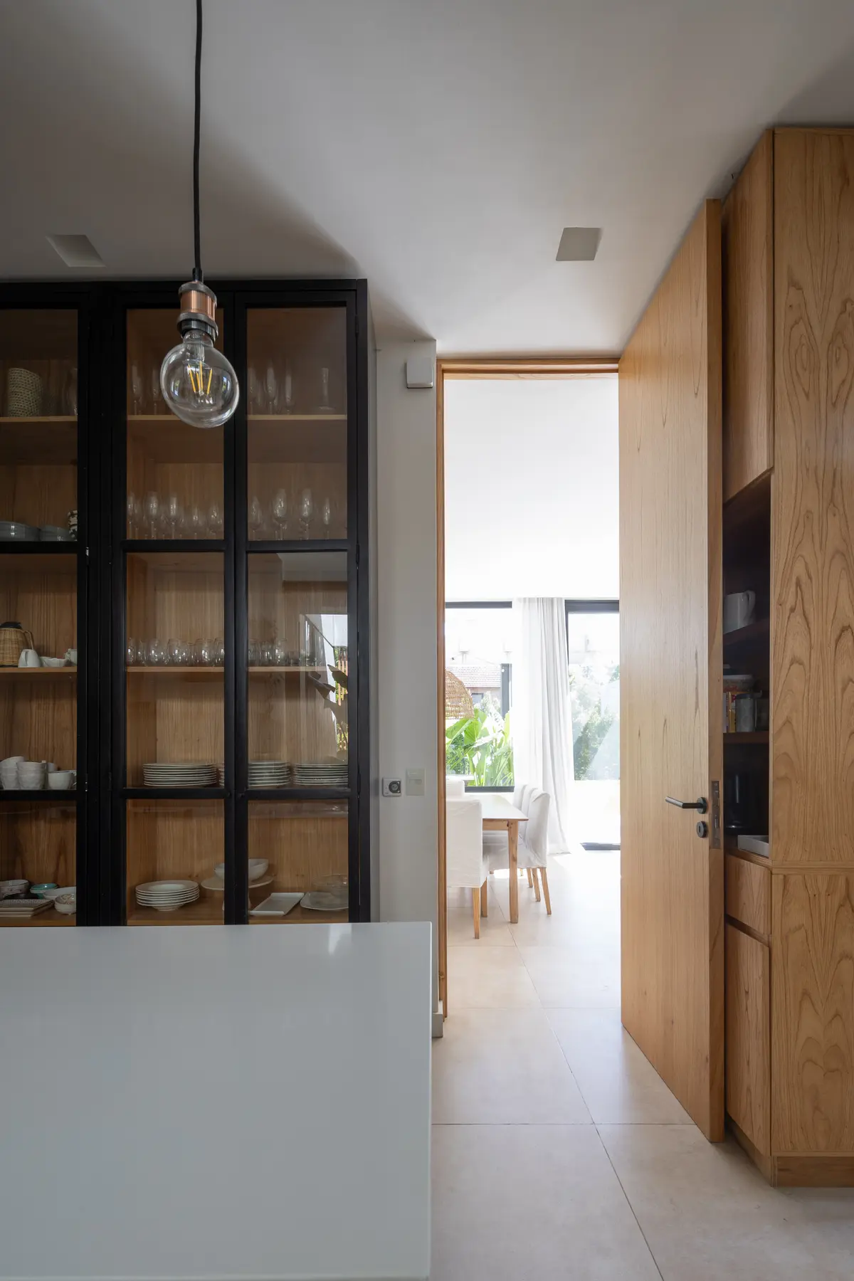 Cocina moderna de planta abierta con vitrinas y muebles de madera — proyecto CASA RuZa, por Alfredo Orfila arquitectura, en Benavidez
