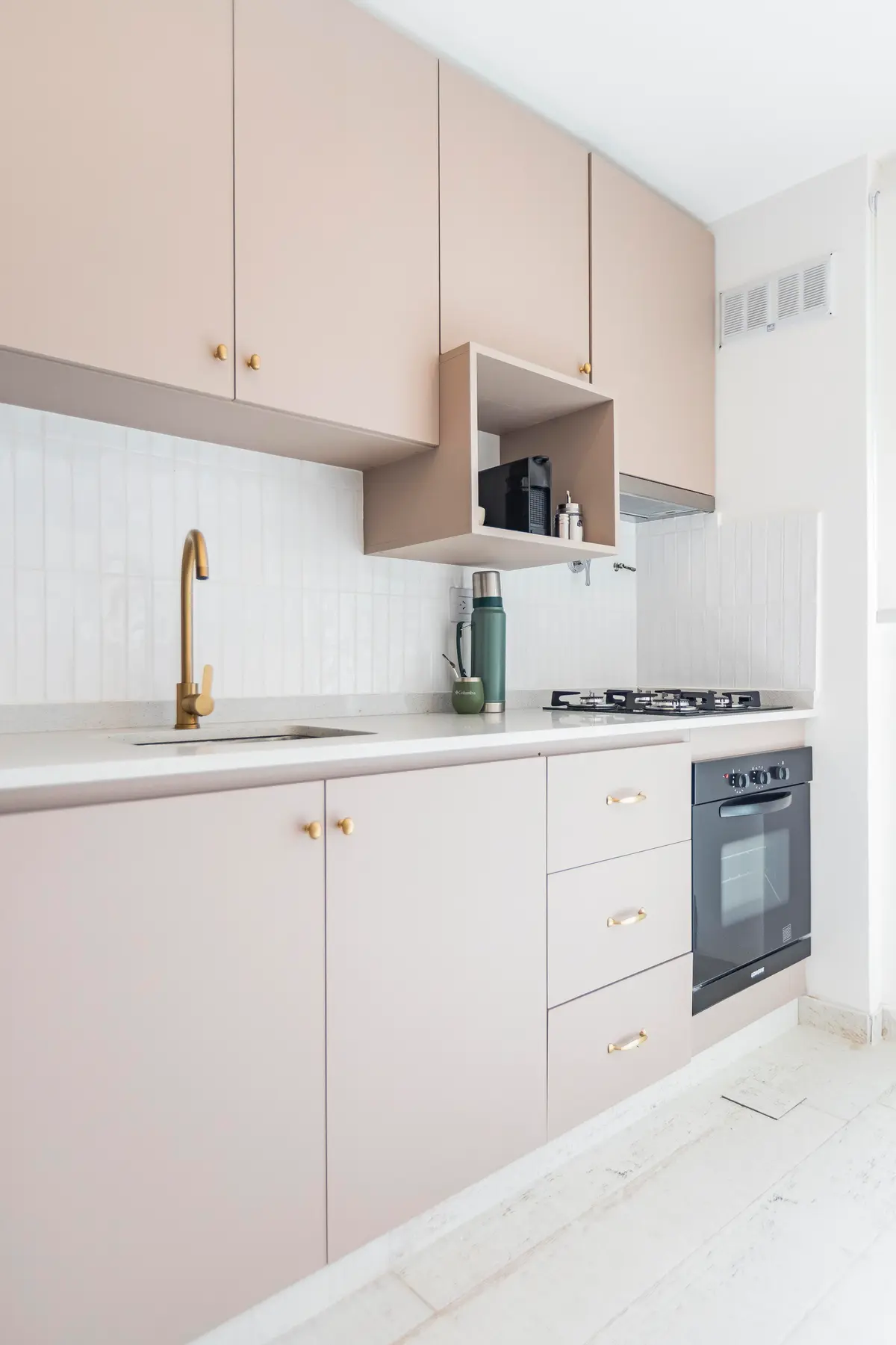 Cocina moderna minimalista con gabinetes beige y grifería de latón — proyecto Remodelacion departamento en Belgrano, por MSMC, en Buenos Aires