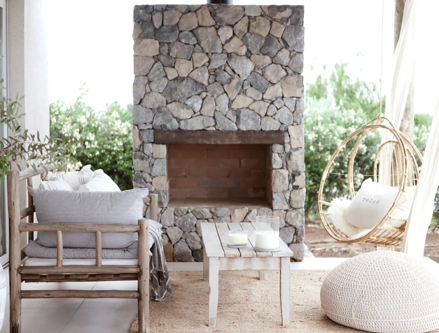 terraza rústica con chimenea de piedra y silla colgante