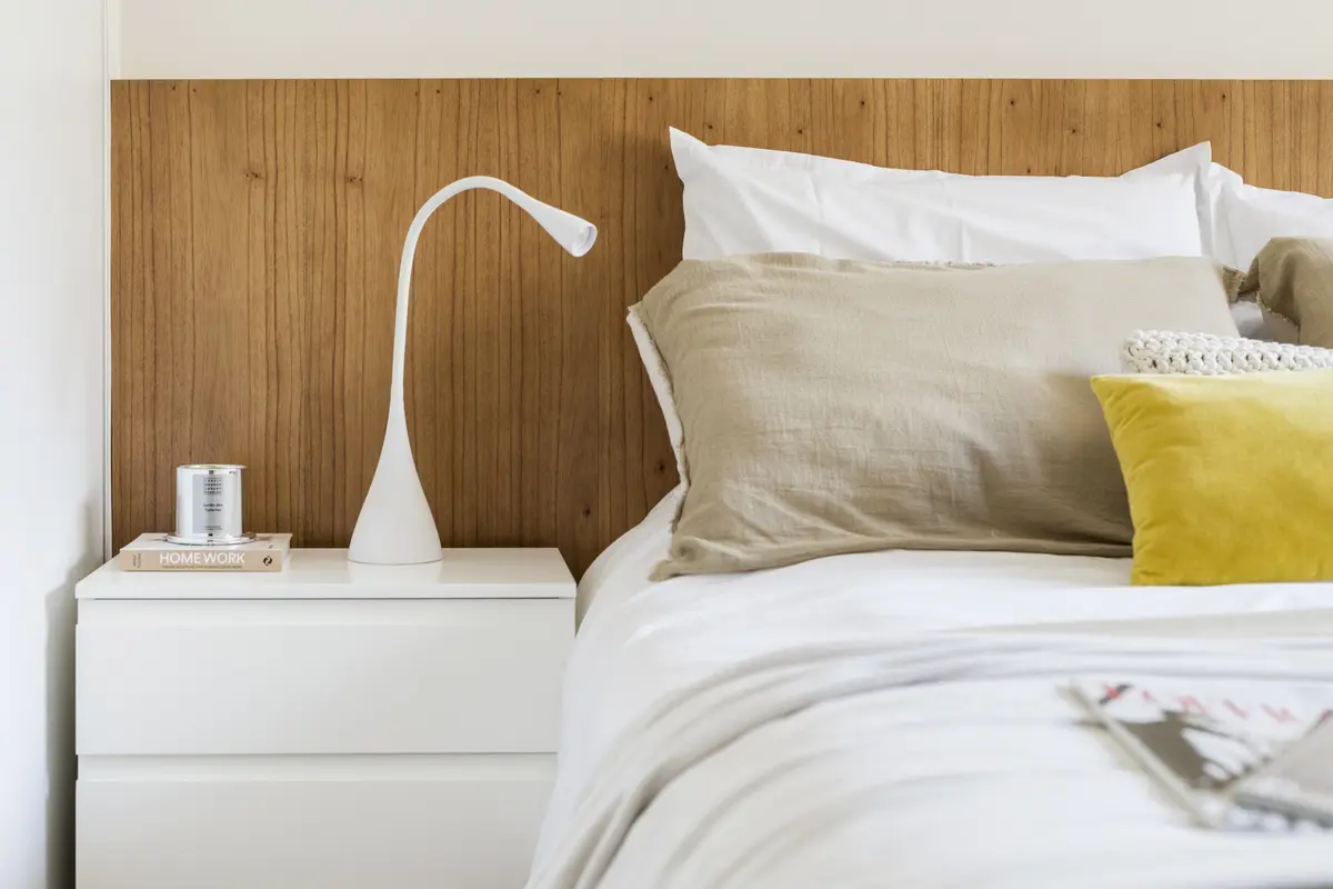 Dormitorio moderno con cabecero de listones de madera y luz cálida — proyecto Mansilla, por Estudio Basa, en CABA