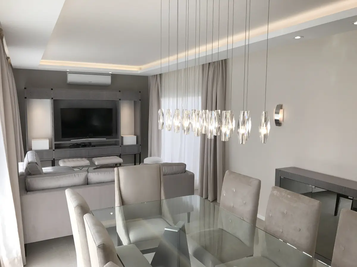 Living comedor moderno, suelo de madera, luces colgantes de cristal — proyecto Obra Nueva York, por Estudio Nicolás Pierry, en CABA