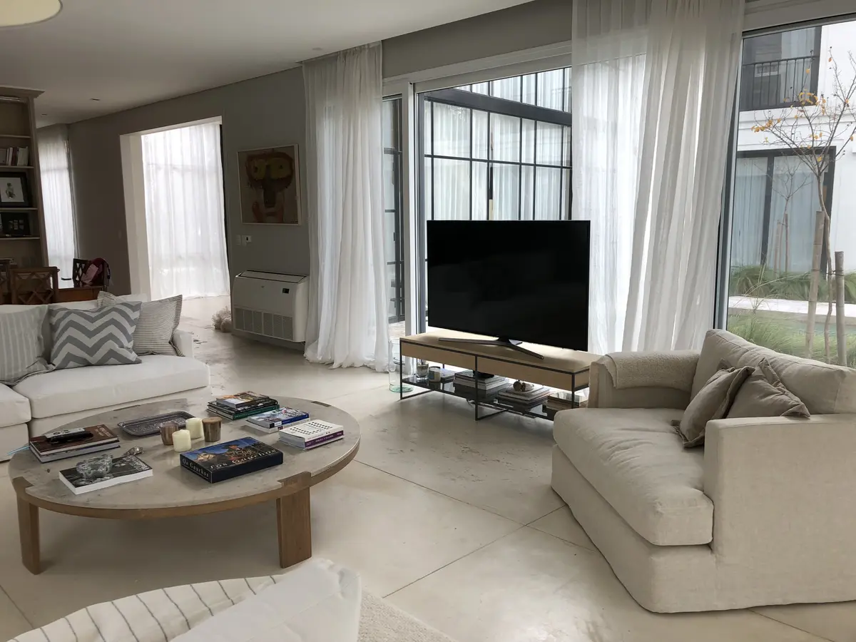Living moderno con sofá grande y ventanales amplios — proyecto CASA DEL PUENTE, por Estudio Xime Fontan Balestra, en General Pacheco