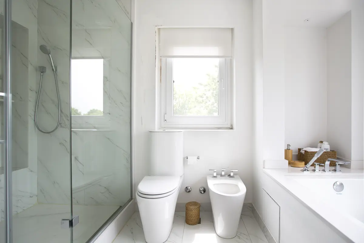 Baño moderno con mármol, bañera exenta y gran ventana — proyecto Casa W, por Estudio Junor, en Ayres de Pilar Barrio Cerrado