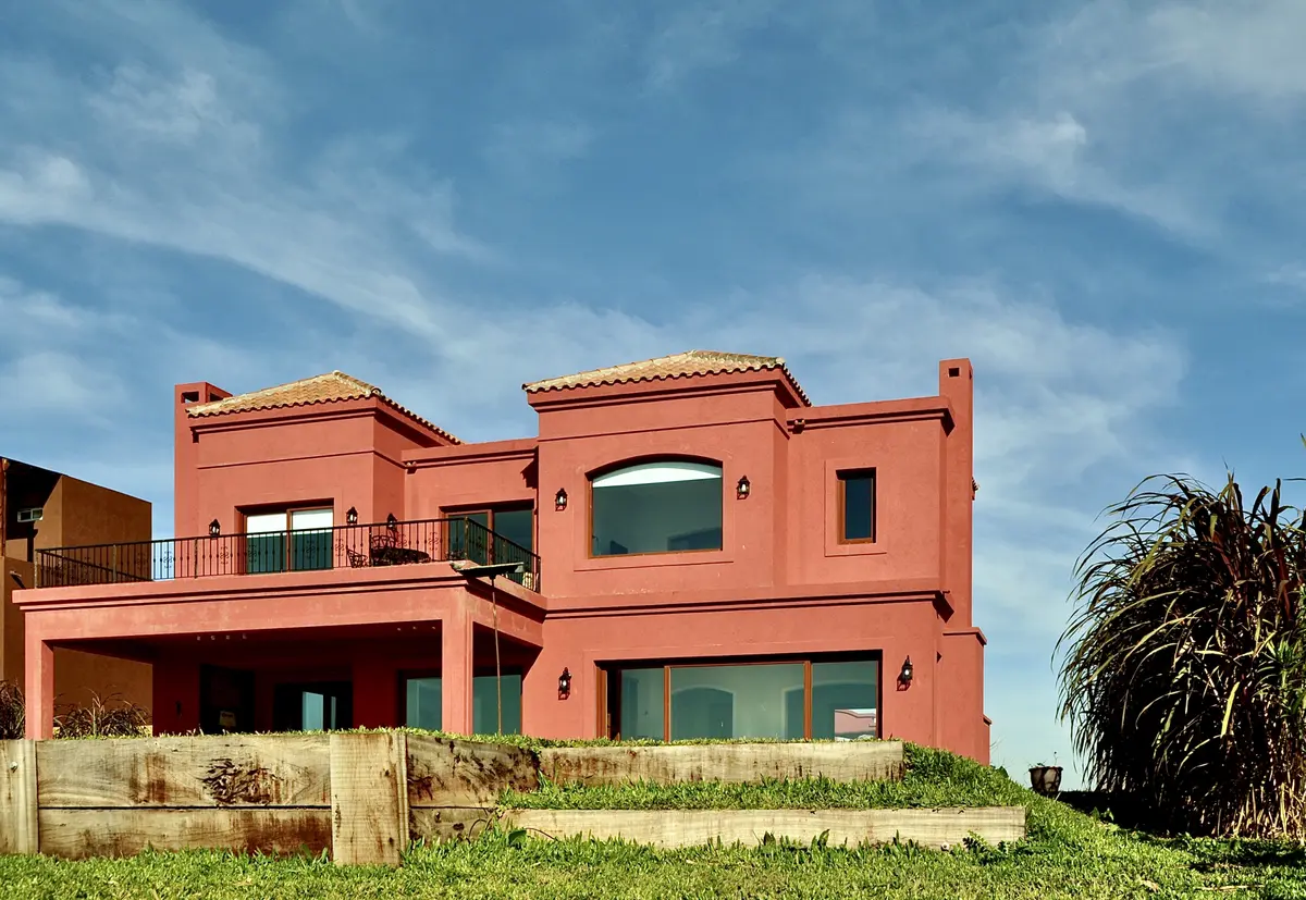fachada de casa estilo mediterrâneo com galeria e grandes janelas — projeto San Marcos 2, por Marconi Silva Arquitectos, em Benavidez
