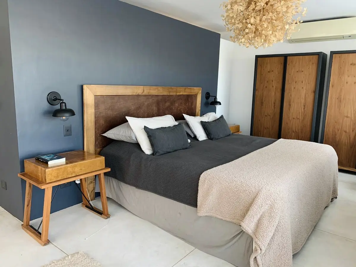 Dormitorio moderno con paredes azules, armario de madera y lámpara colgante texturizada — proyecto Tigre , por Greschek Obras , en Tigre