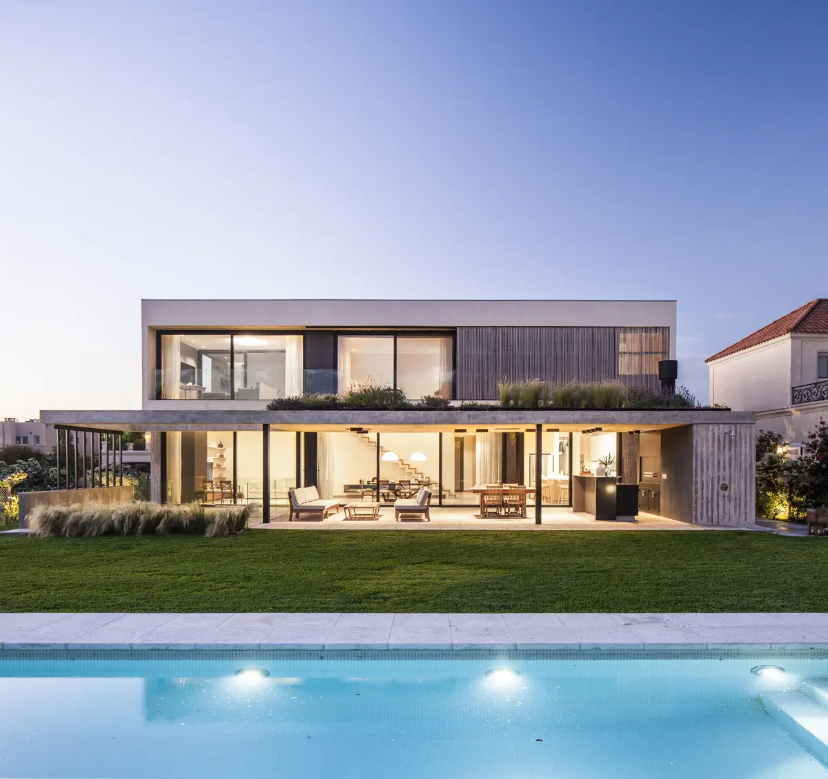Casa moderna cinza de concreto com grandes janelas e piscina — projeto CASA R, por GMARQ