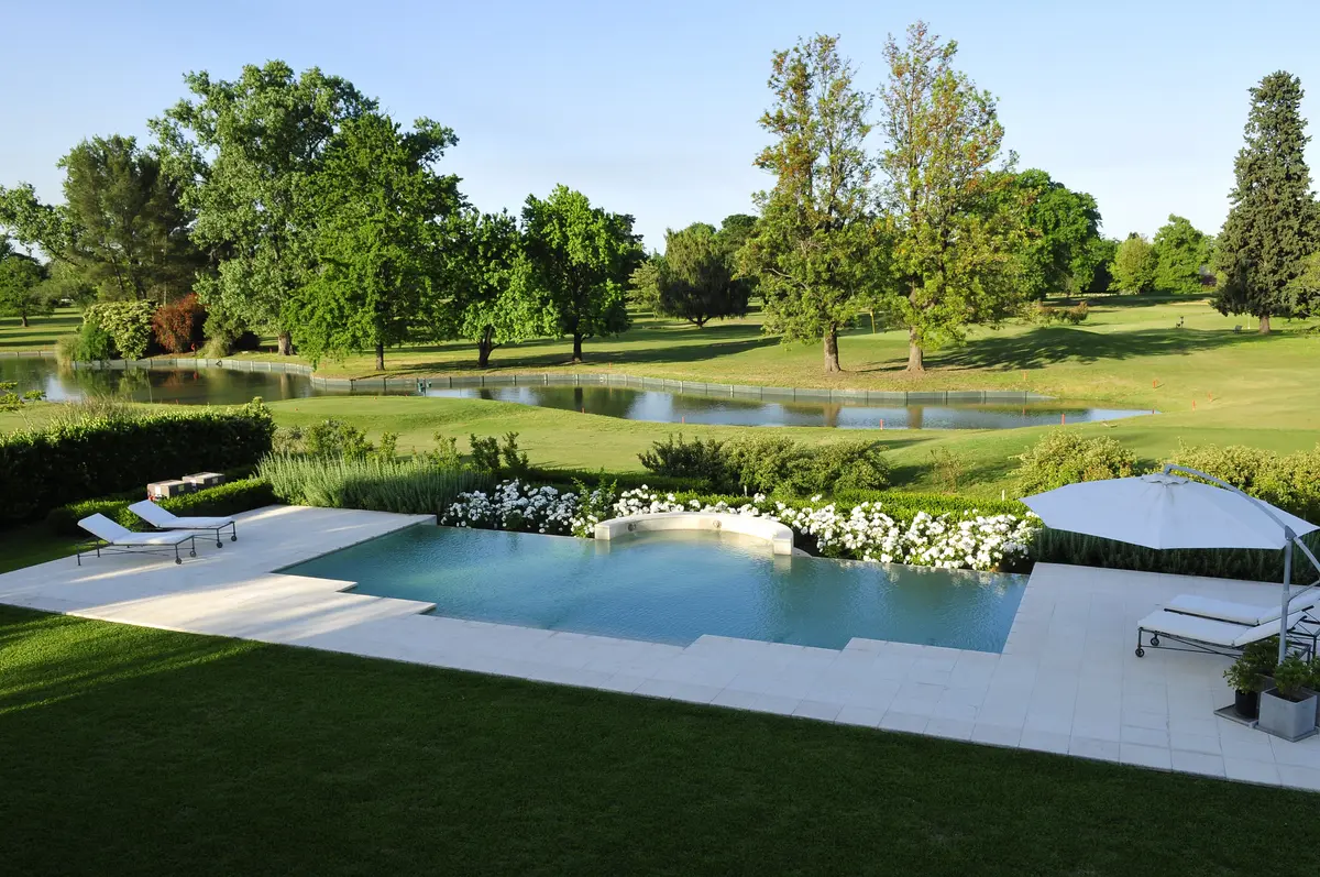 piscina infinita moderna con deck de madera y vegetación exuberante — proyecto Desde La Toscana, por Oppel Arquitectura