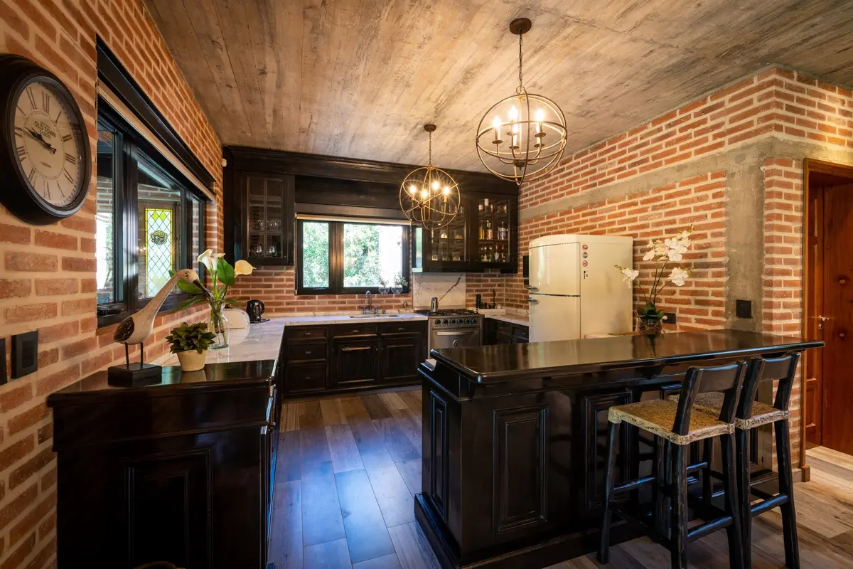 Cozinha rústica industrial com tijolo aparente e madeira escura — projeto CASA DE LADRILLOS, por Karlen Clemente