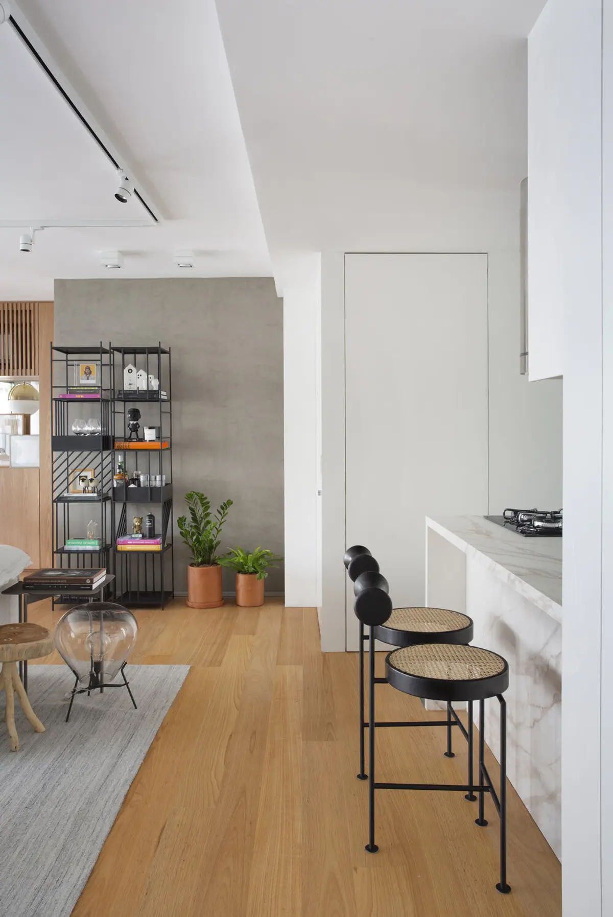 Cocina minimalista con mesada de mármol, taburetes negros y doble altura — proyecto JG House, por Studio Ro-ca