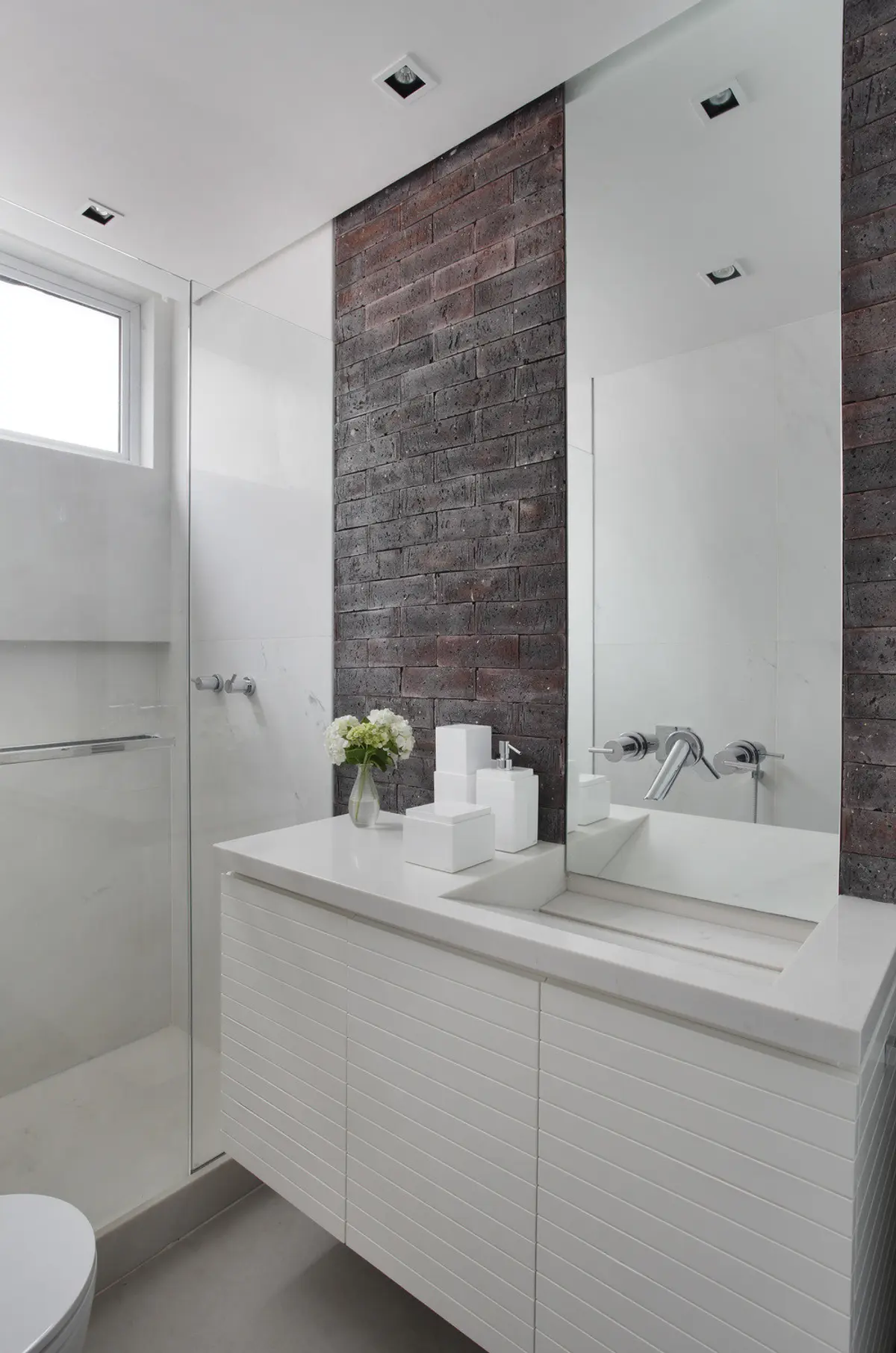 Baño moderno minimalista con mesada blanca, espejo grande y pared ladrillo — proyecto VF House, por Studio Ro-ca