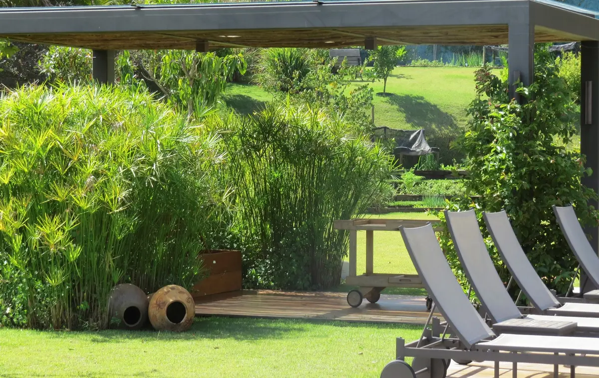 Patio con pergola, deck y jardineras, loungers frente al cesped — proyecto Residencia PZ, por Gil Fialho