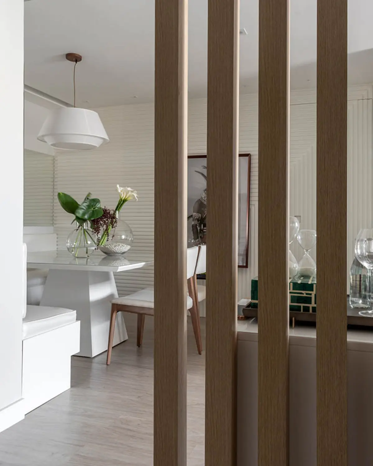 Pasillo con columnas de madera que separan ambientes minimalistas — proyecto Apartamento Santa Rosa, por Amanda Miranda