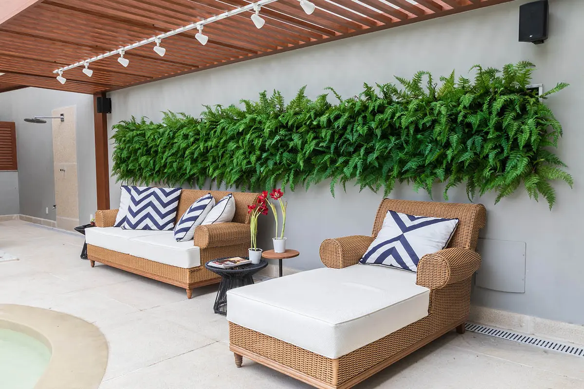 Terraza moderna con muebles de rattan, muro verde y pergola de madera — proyecto Casa Barra ED, por Amanda Miranda