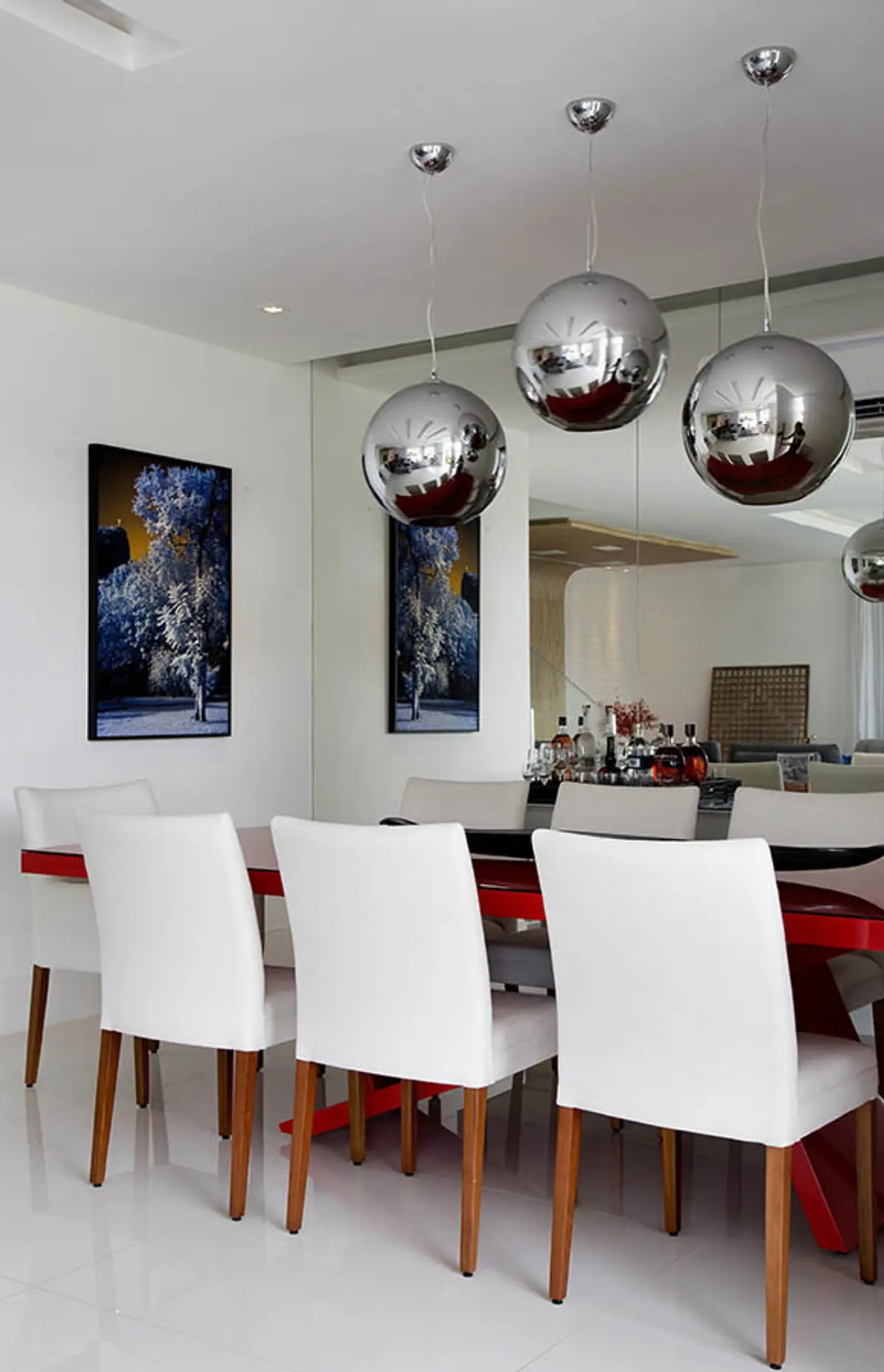 Comedor moderno con sillas blancas y lámparas esféricas metalizadas — proyecto Casa Blue House, por Amanda Miranda