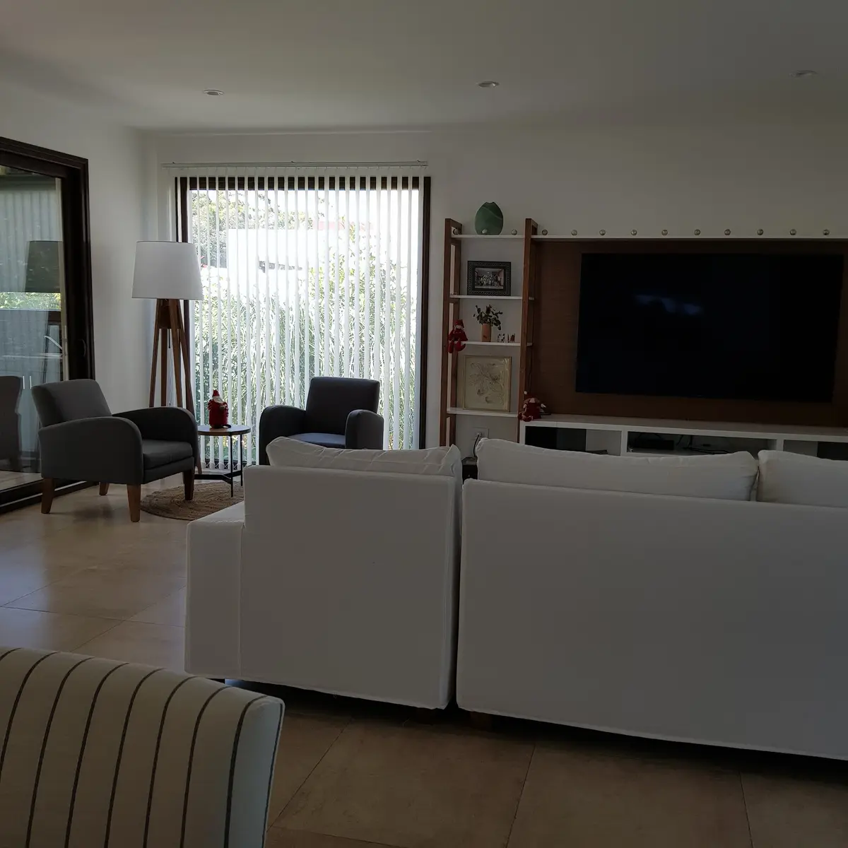 Living moderno con sofá blanco y ventanales amplios — proyecto Casa FA, por Vicky Hurrell, en Mar del Plata
