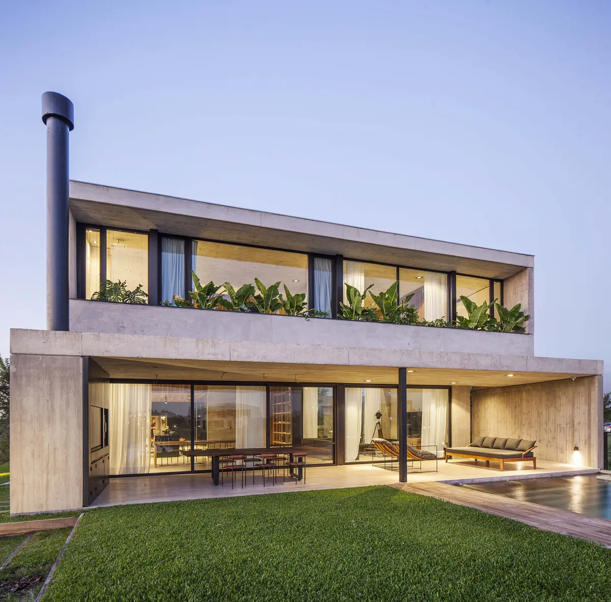 casa moderna de concreto com grandes janelas e piscina — projeto Casa Sakura, por Estudio PK