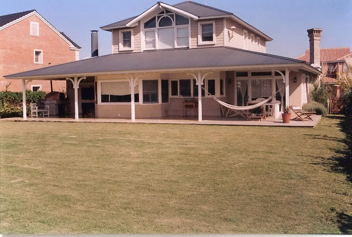Amplio patio cubierto con pérgola, parrillero y hamaca — proyecto Casa en Nordelta, por Rioja Arquitectura, en Nordelta