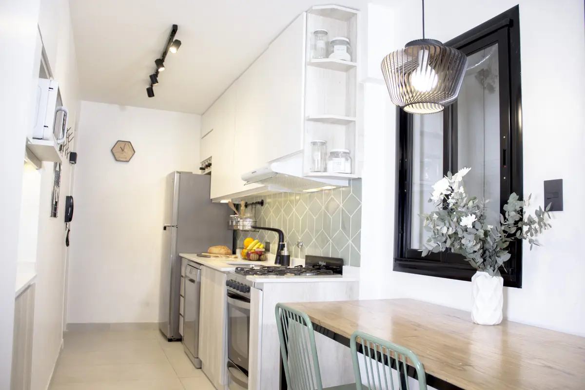 Cocina minimalista con mesada de madera y equipamiento integrado — proyecto Guido, por Fainteriores, en CABA