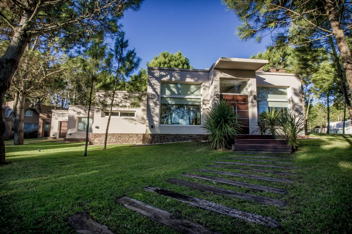 Casa moderna com jardim exuberante e amplas janelas — projeto Vivienda Unifamiliar en Pinamar, por Estudio Schifano, em Pinamar