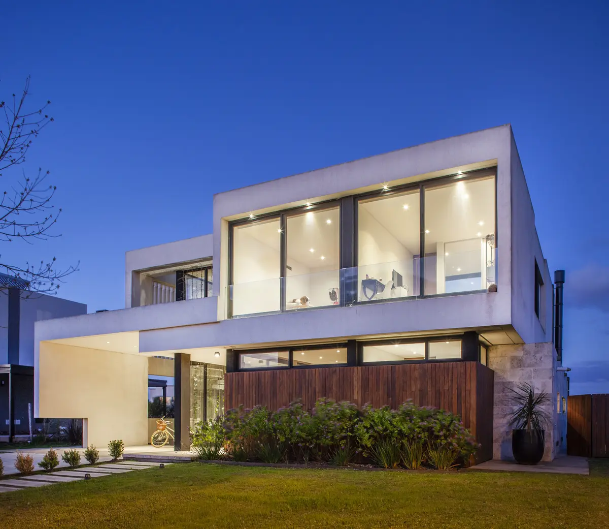 fachada moderna de dois andares com detalhes em madeira e grandes janelas — projeto Casa BJM, por Vanguarda Arquitectos, em Belén de Escobar