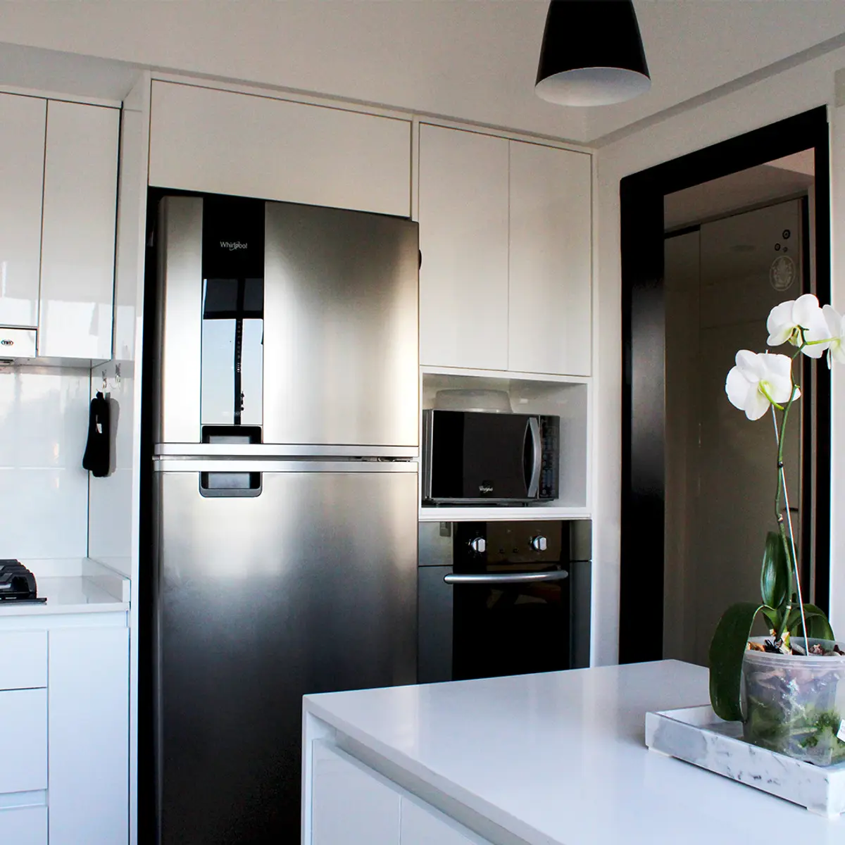 Cocina moderna blanca y negra con isla central de mármol — proyecto DEPTO OH, por Estudio Grupo 32, en Buenos Aires