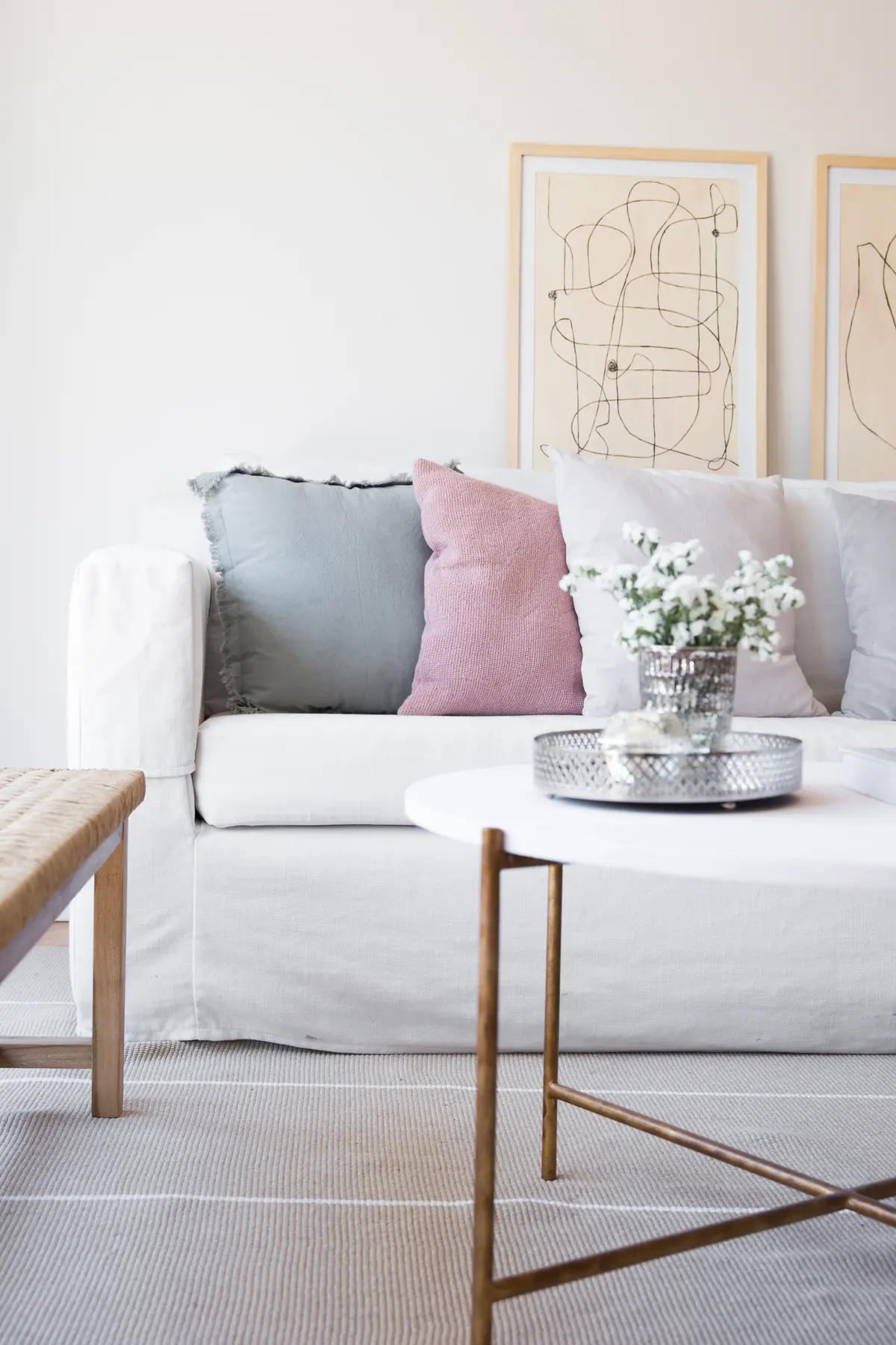 Sala de estar escandinava com sofá branco, tapete listrado e arte abstrata — projeto Proyecto Parana, por Olivia D