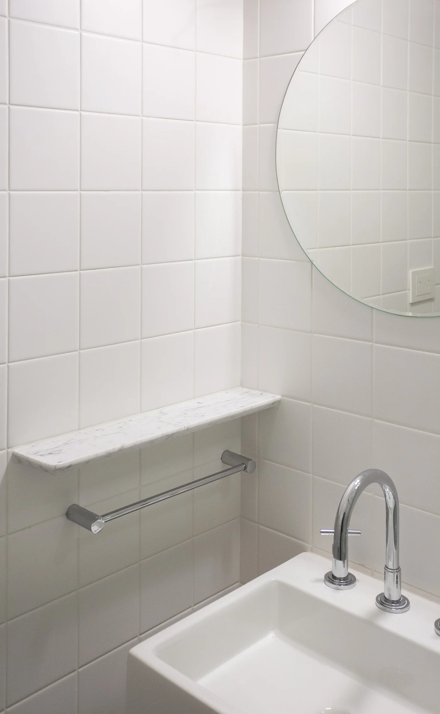 baño moderno blanco con detalles en mármol y cromo