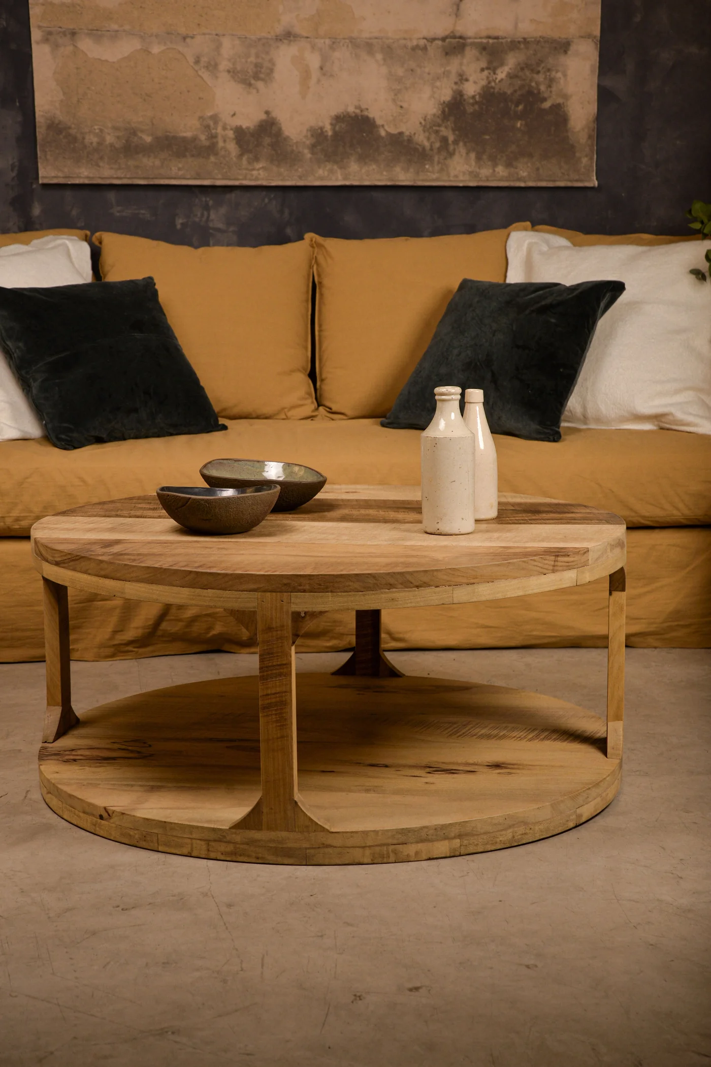 Living moderno rústico con mesa de centro redonda de madera y sofá mostaza