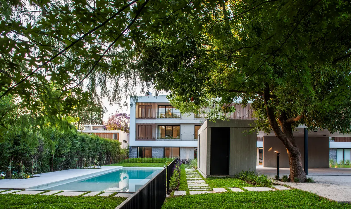 Fachada moderna com piscina e vegetação exuberante — projeto Alvear AV, por V2 Arquitectos, em City Bell