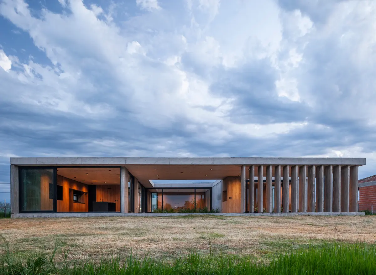 casa moderna de concreto com pátio central e ripas verticais — projeto Casa JUMP, por V2 Arquitectos, em City Bell