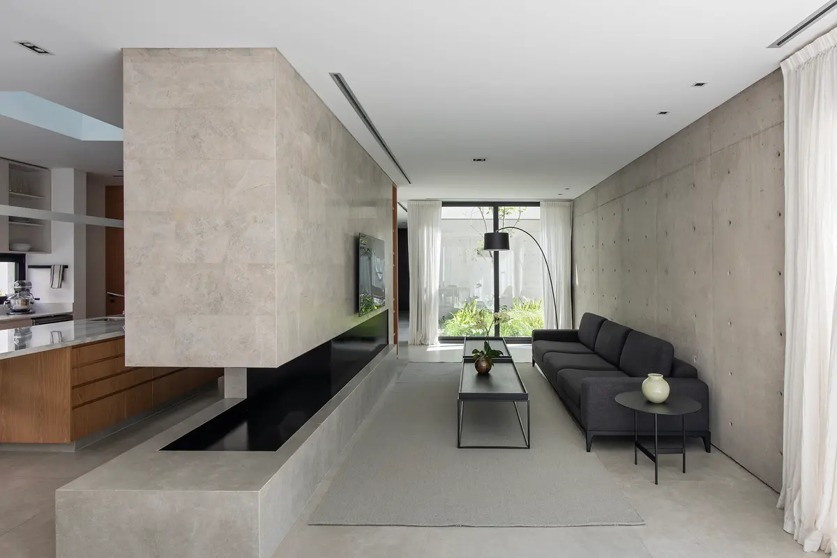 Living moderno con fireplace de piedra y hormigón visto — proyecto CASA SD28, por GMARQ, en Buenos Aires