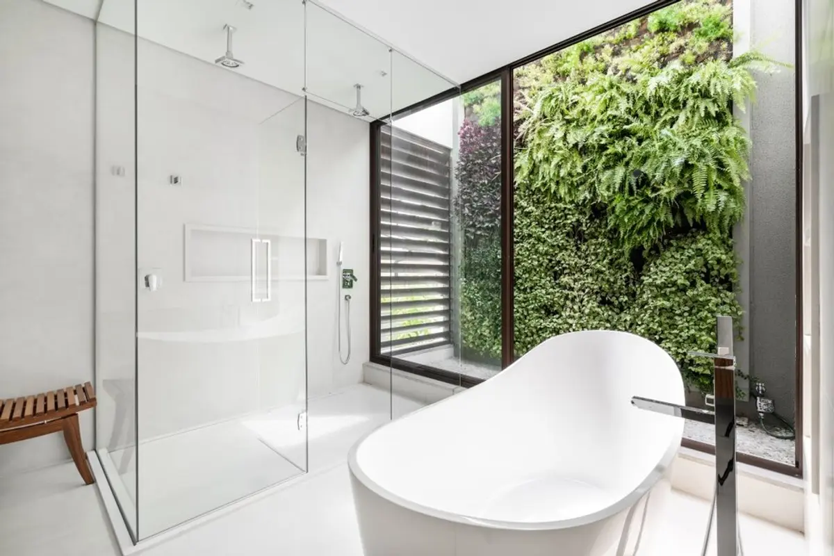 Banheiro moderno com parede verde e banheira freestanding — projeto Projeto AV, por Alexandre Galhego Paisagismo