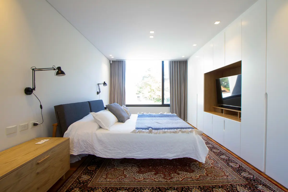 Dormitorio moderno con armario empotrado y alfombra ornamental — proyecto CASA BPO, por radovic_arquitecto, en San Isidro