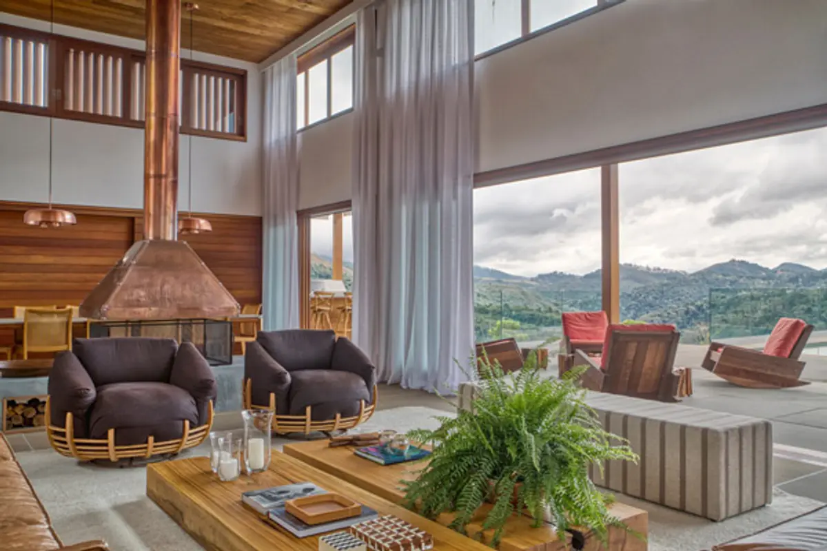 Sala moderna com lareira cônica e vista para montanha — projeto Fazenda Santo Antônio, por Sadala.Gomide Arquitetura