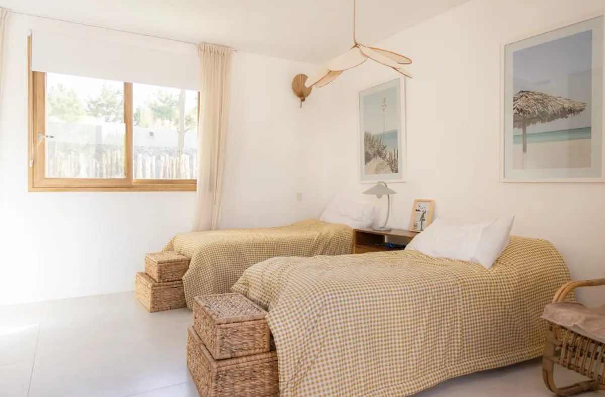 Quarto costeiro com duas camas e arte de praia — projeto El Refugio, por Grupo Pauta Arquitectura, em Pinamar