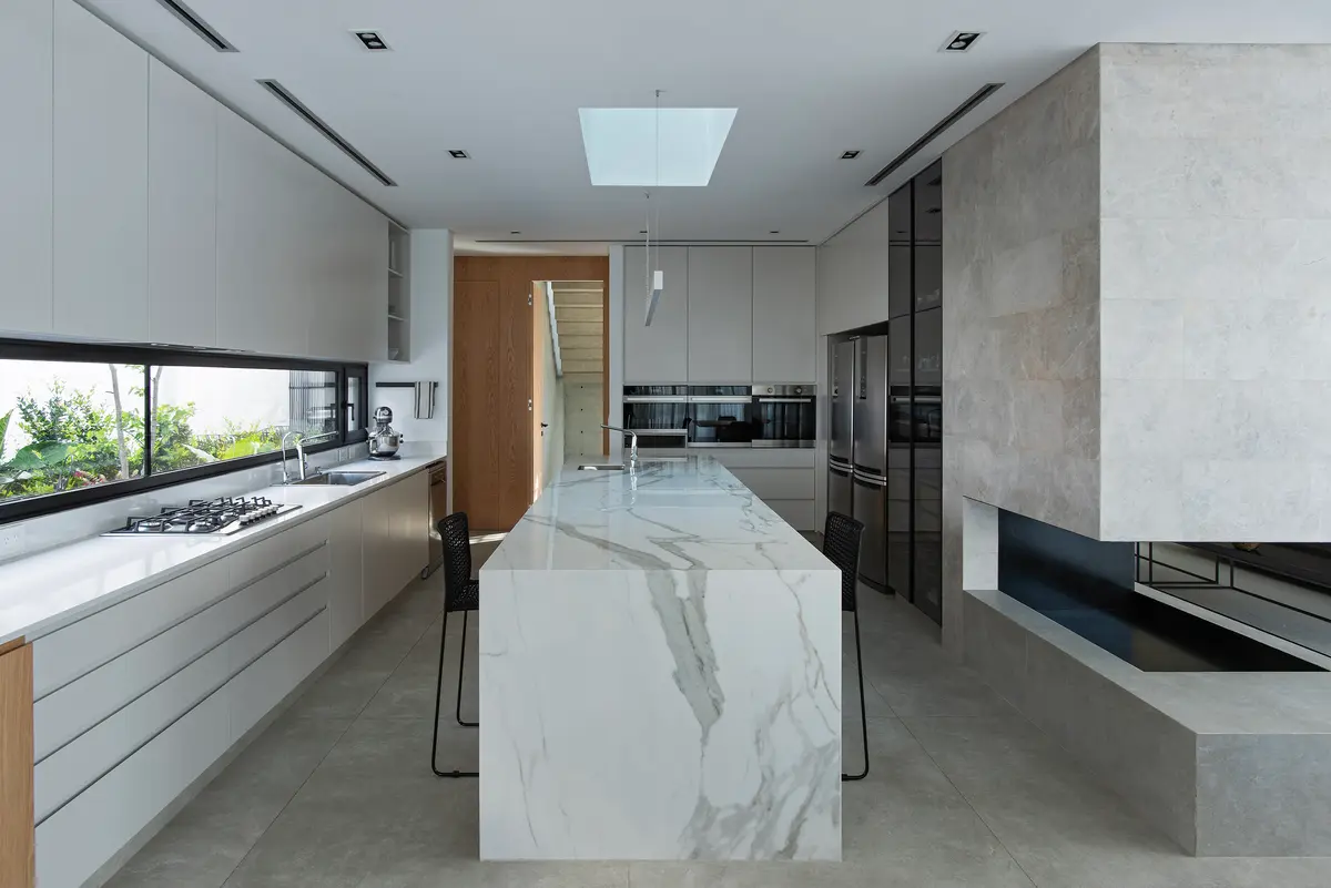Cocina moderna minimalista con isla de mármol y amplios ventanales — proyecto CASA SD28, por GMARQ, en Buenos Aires