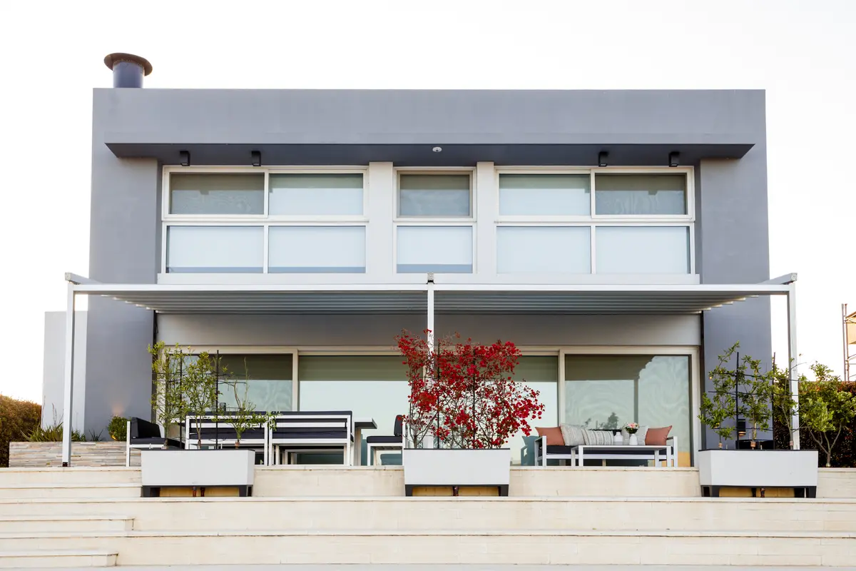 Fachada moderna de casa de dois andares com terraço e jardim — projeto TOLDER - PERGOLAS, por Argentina en Obra 2024, em Rincón de Milberg