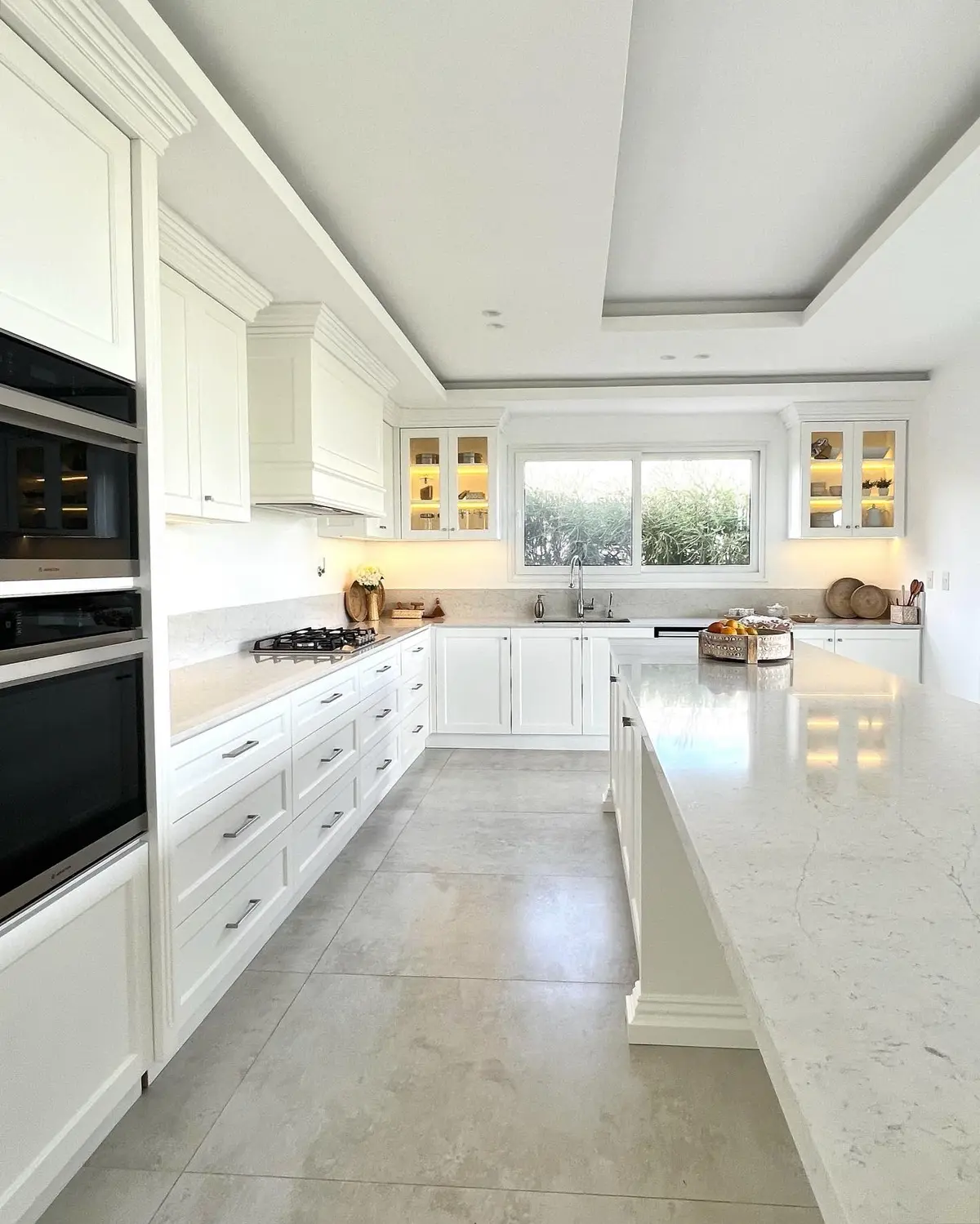 Cozinha moderna clássica com ilha e detalhes em mármore branco — projeto Cocina real, por Wiarq, em Belén de Escobar