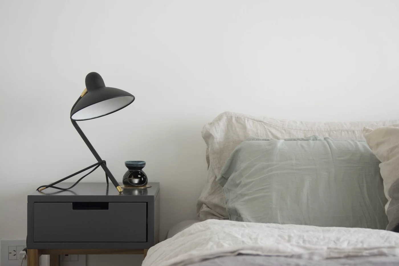 Dormitorio minimalista con cama y lámpara de escritorio