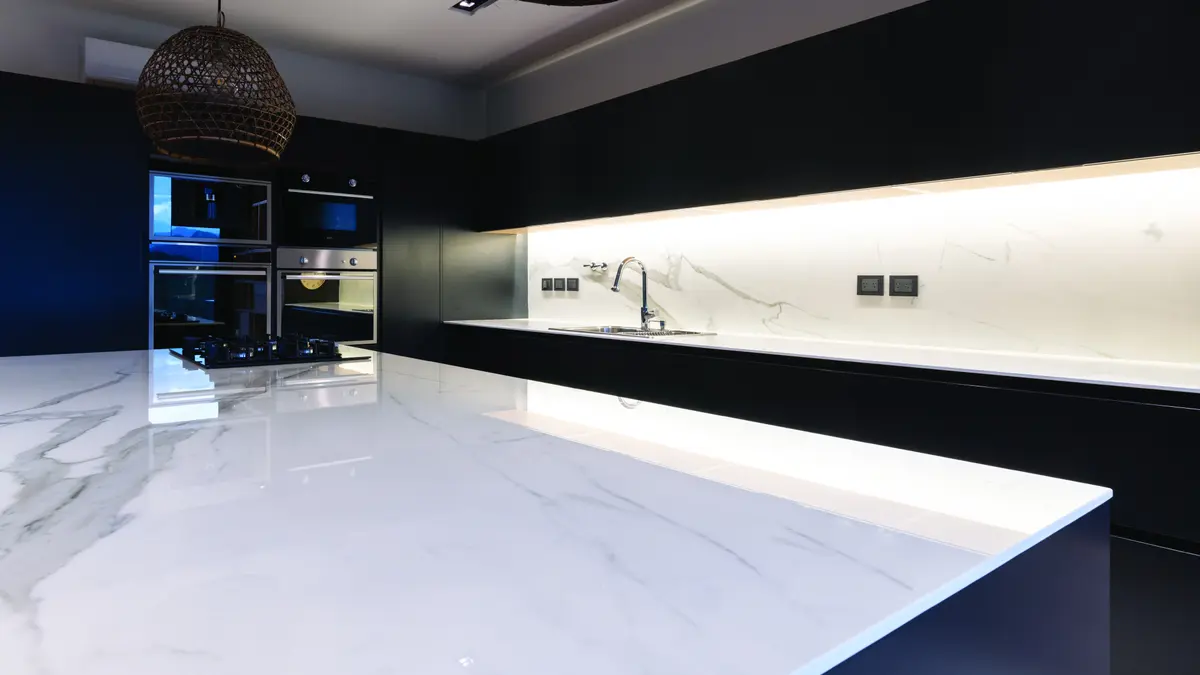 Cozinha moderna com ilha grande de mármore branco e armários pretos — projeto COCINAS, por DE STEFANO