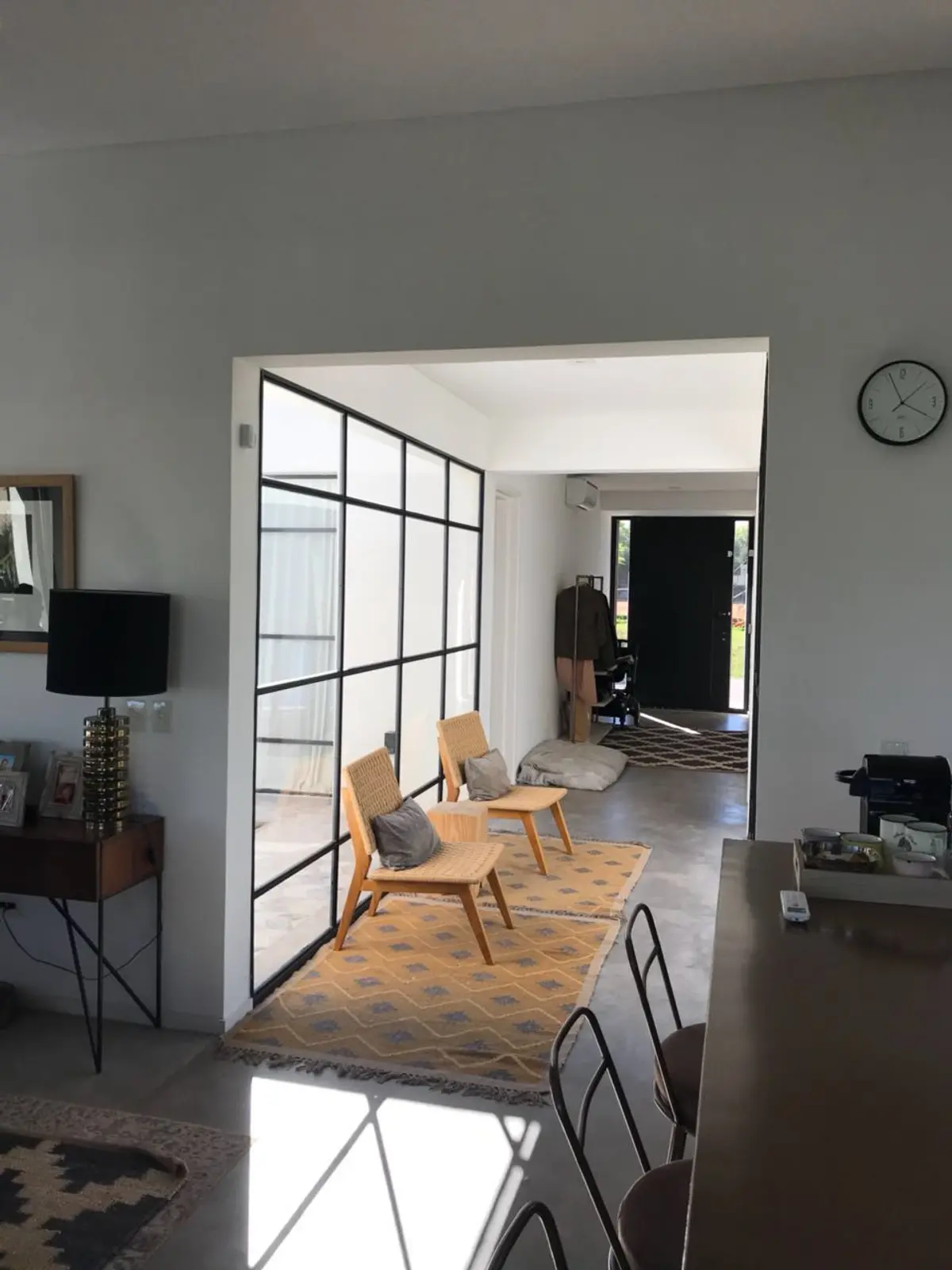 Sala de estar moderna con grandes ventanales y mobiliario minimalista — proyecto Casa Las Liebres, por Mazzinghi Sanchez, en Garin