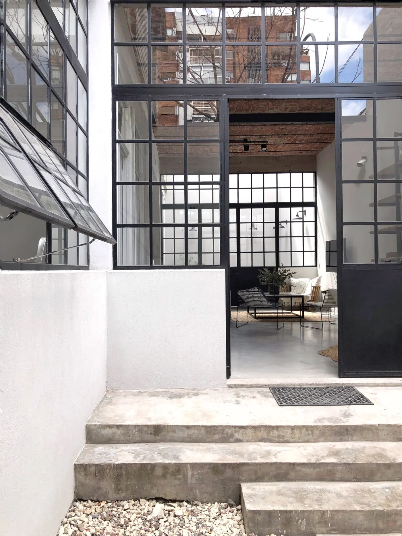 Fachada industrial con amplios ventanales y escalera de hormigón